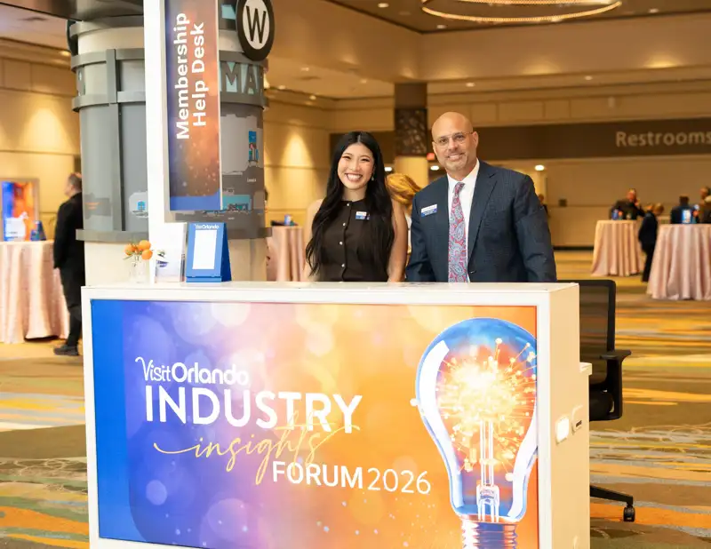 Registration staff welcome attendees at the branded forum desk.