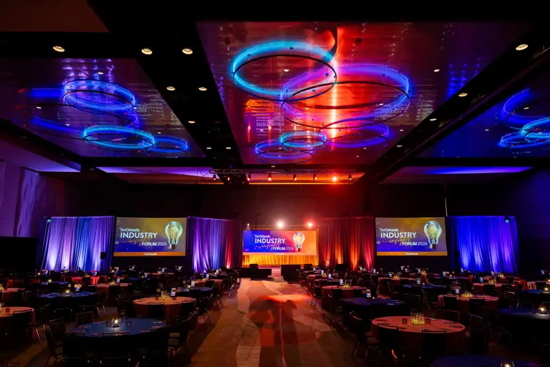 Blue and orange lighting across the forum stage and room.