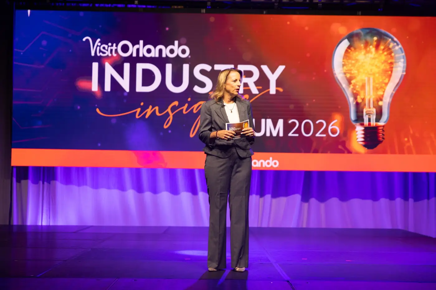 A speaker in a dark suit stands in front of the Industry Insights Forum 2026 screen.