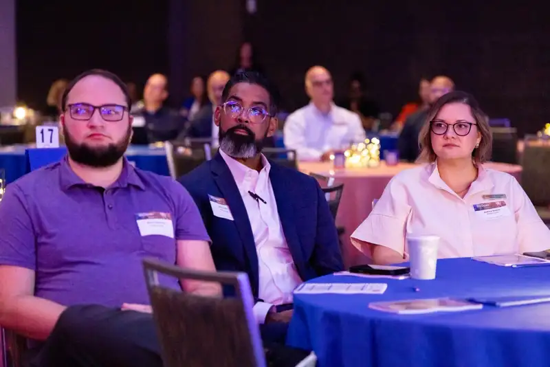 A group of attendees pose together at their table.