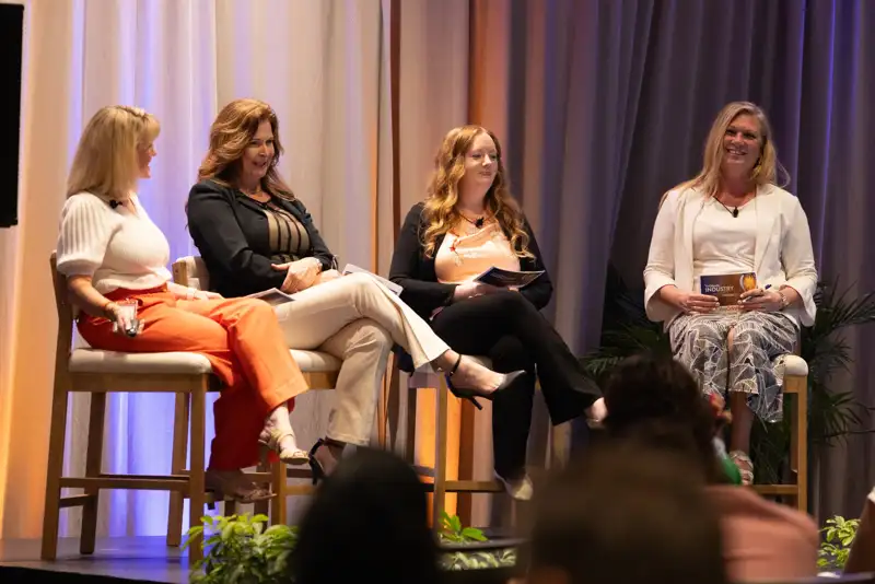 Three panelists seated together during a discussion.