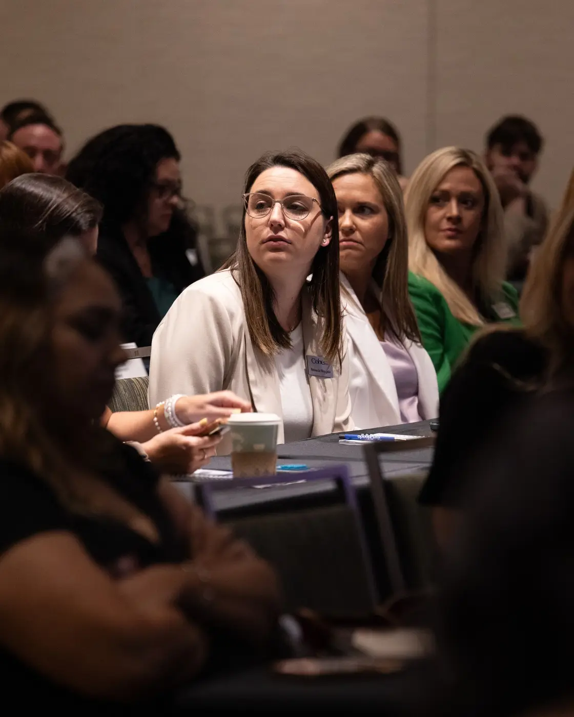 Attendees listen to a discussion around a conference table.