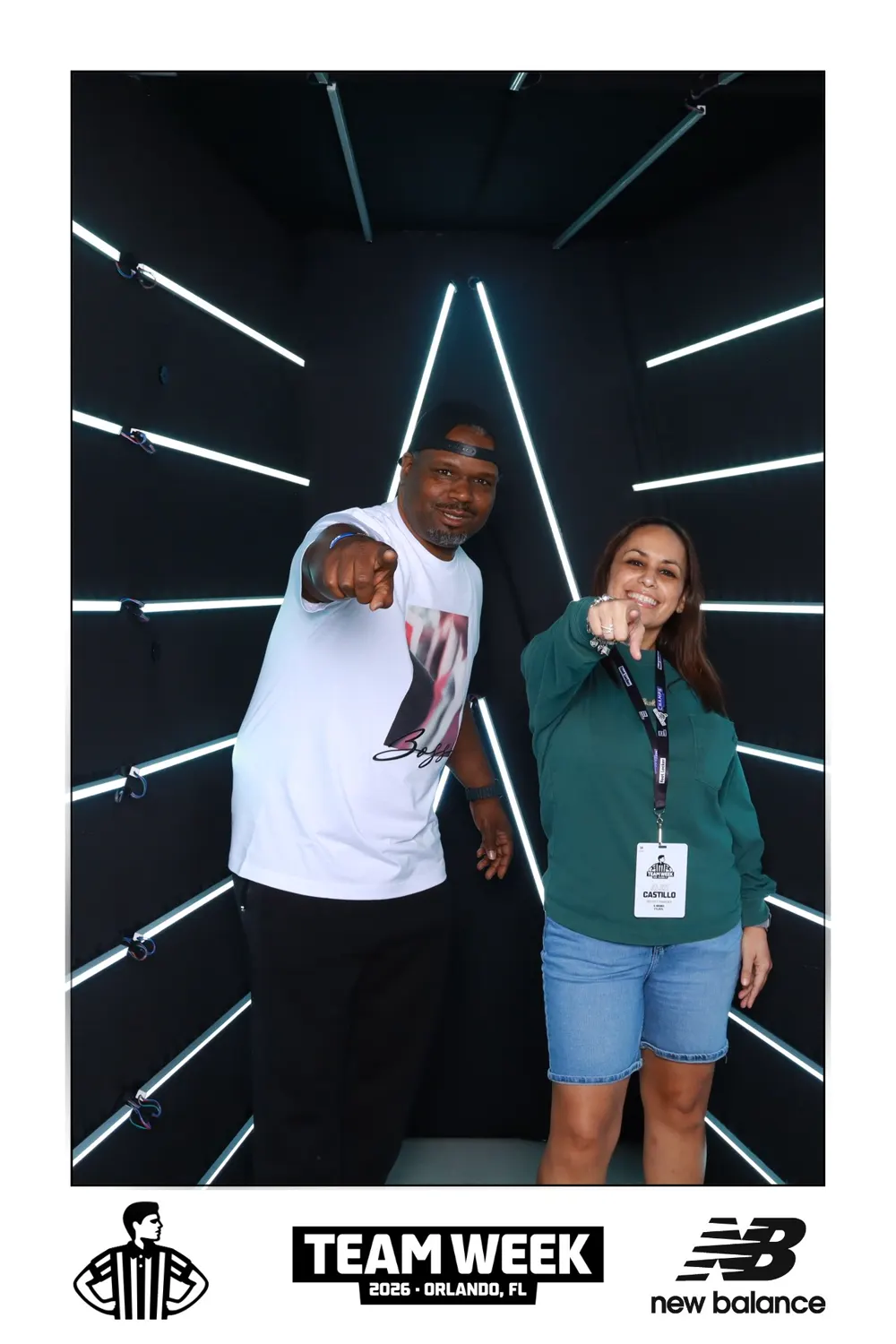 Two guests posing in the illuminated Foot Locker and New Balance Vogue booth