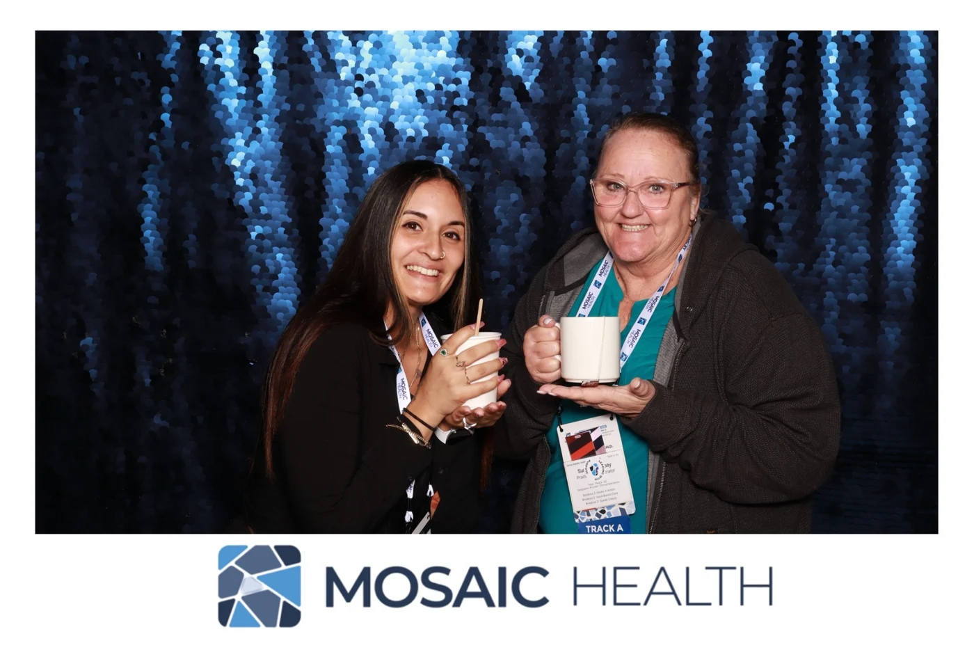 Two retreat guests holding their Mosaic Health photo booth prints
